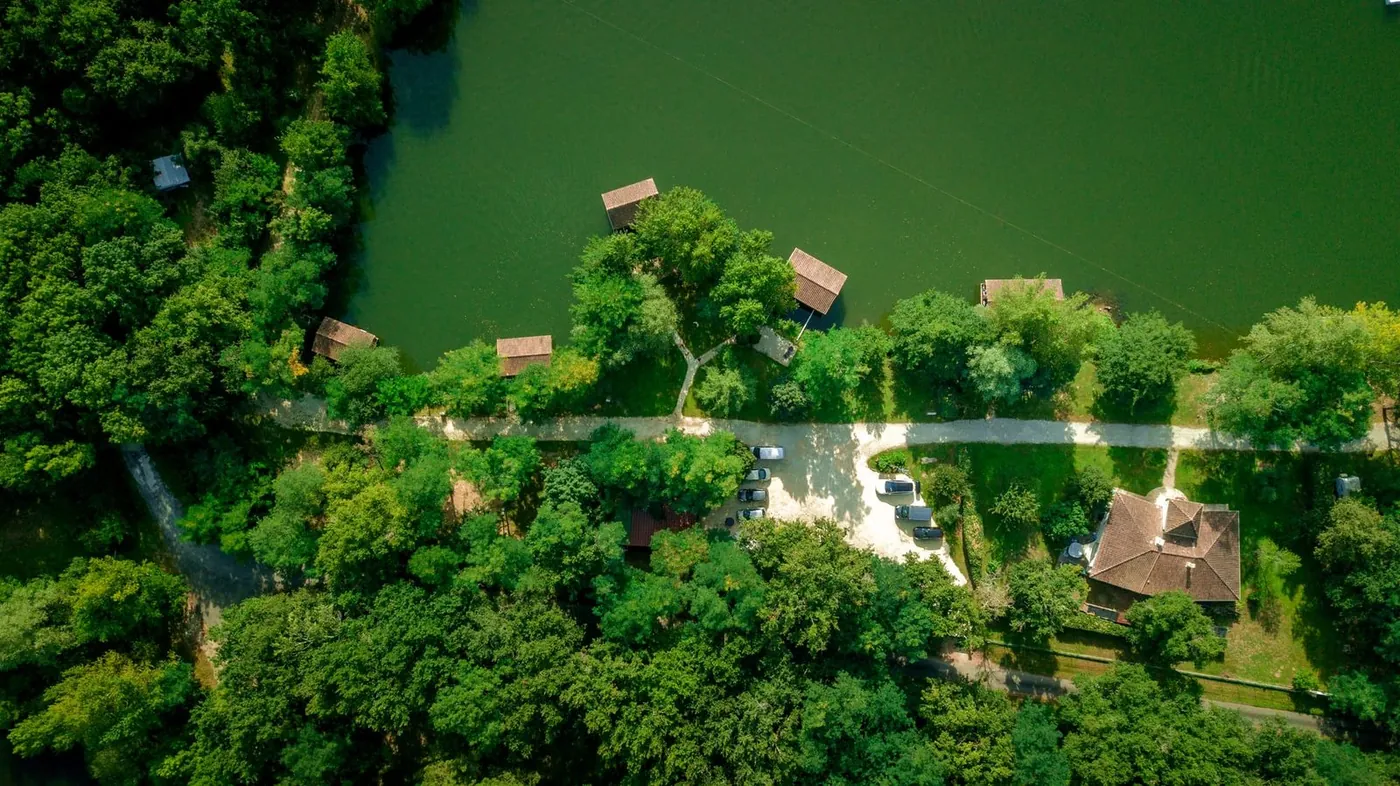 Le Domaine du Dahu vu du ciel : le lac, les chalets et le gîte au milieu des arbres – privatisation du Domaine du Dahu
